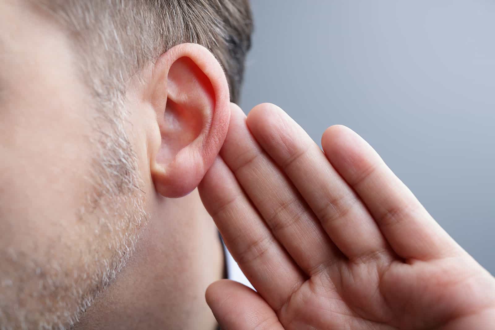 Man holding a hand to his ear