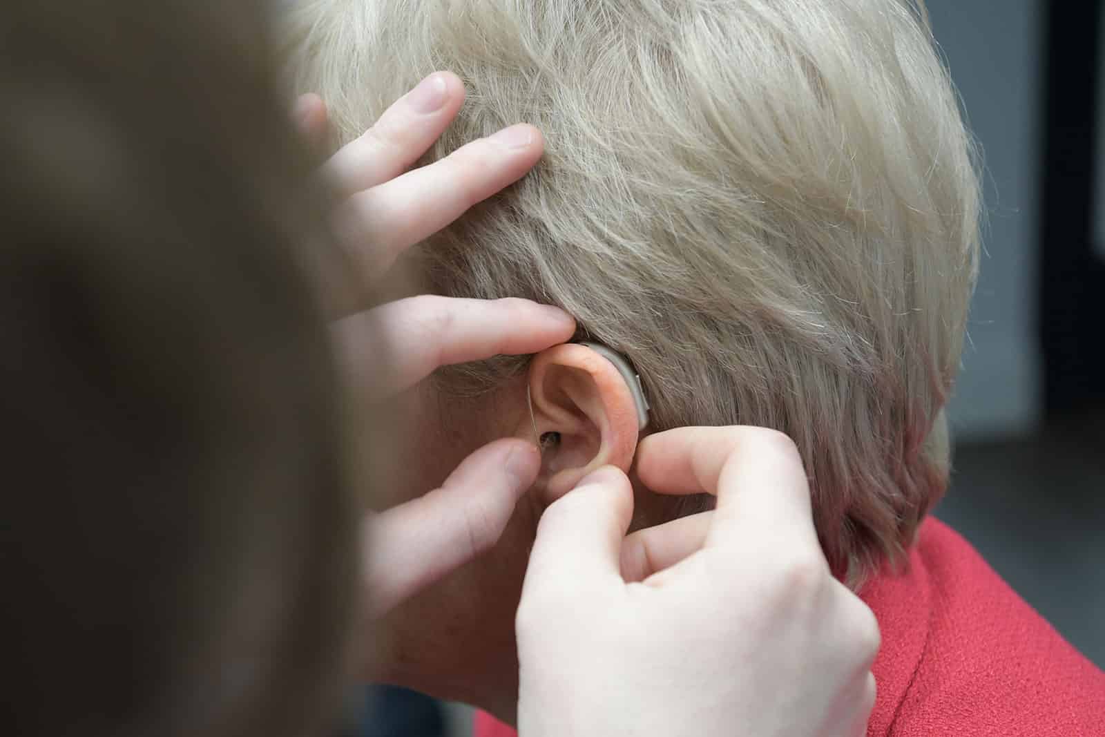 Lady having a hearing aid fitted by an audiologist