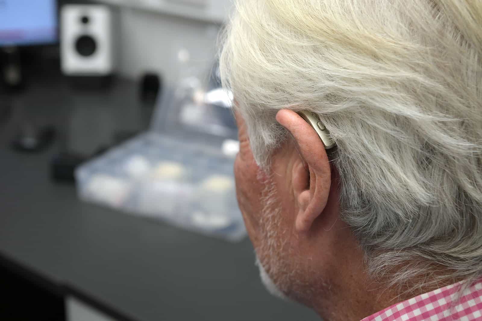 Man's ear showing his hearing aid from behind