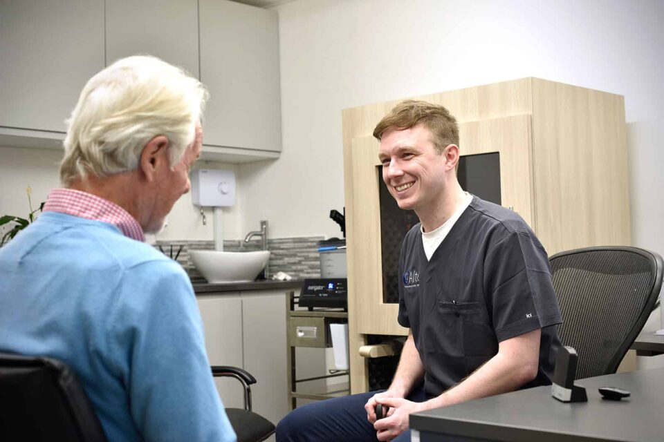 Audiologist explaining hearing test results to a man