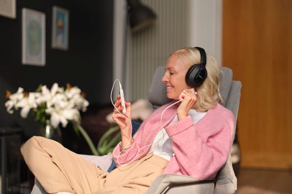Woman using the Lenire tinnitus treatment device