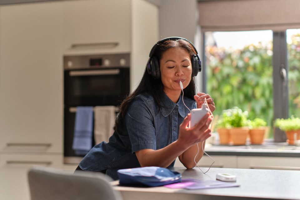 Woman using the Lenire tinnitus treatment device